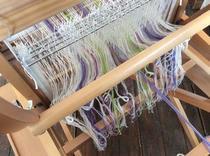 Threading the warp through the heddles and the weave